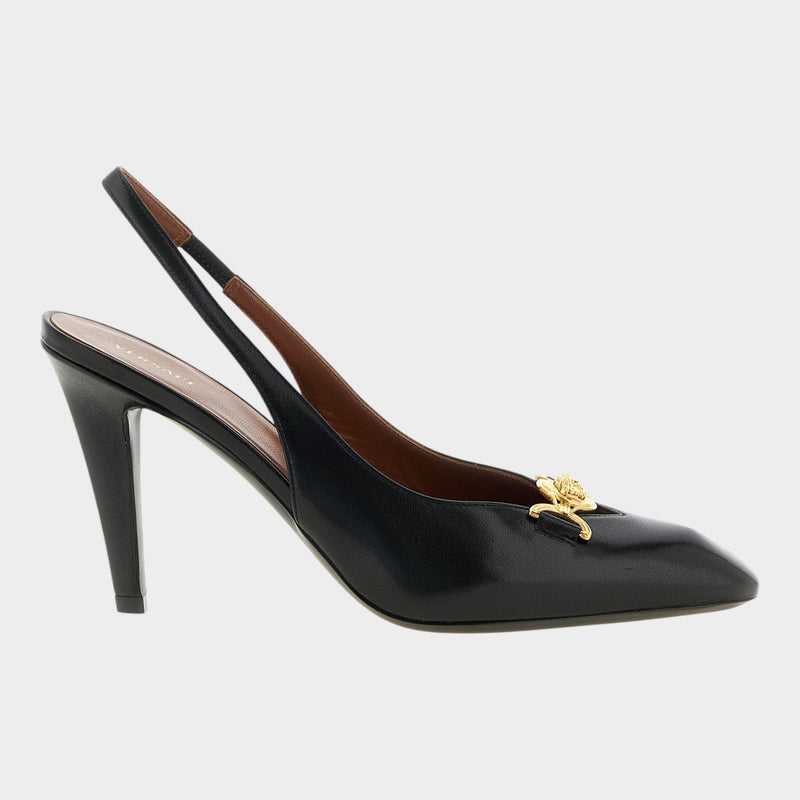 Esmire & Co black lamb leather slingback pumps with a gold Medusa emblem and stiletto heel in a side view.