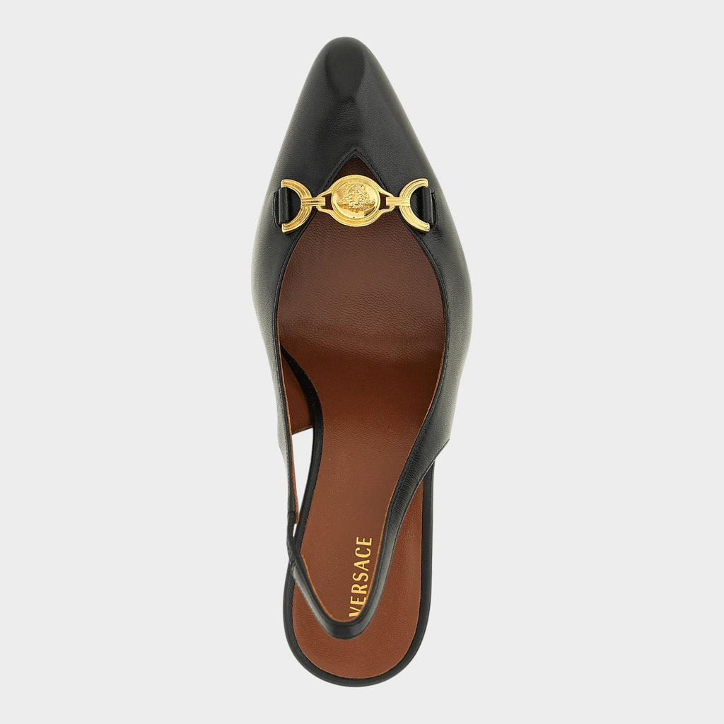 Esmire & Co black lamb leather slingback pumps with gold Medusa hardware and stiletto heel, top view.