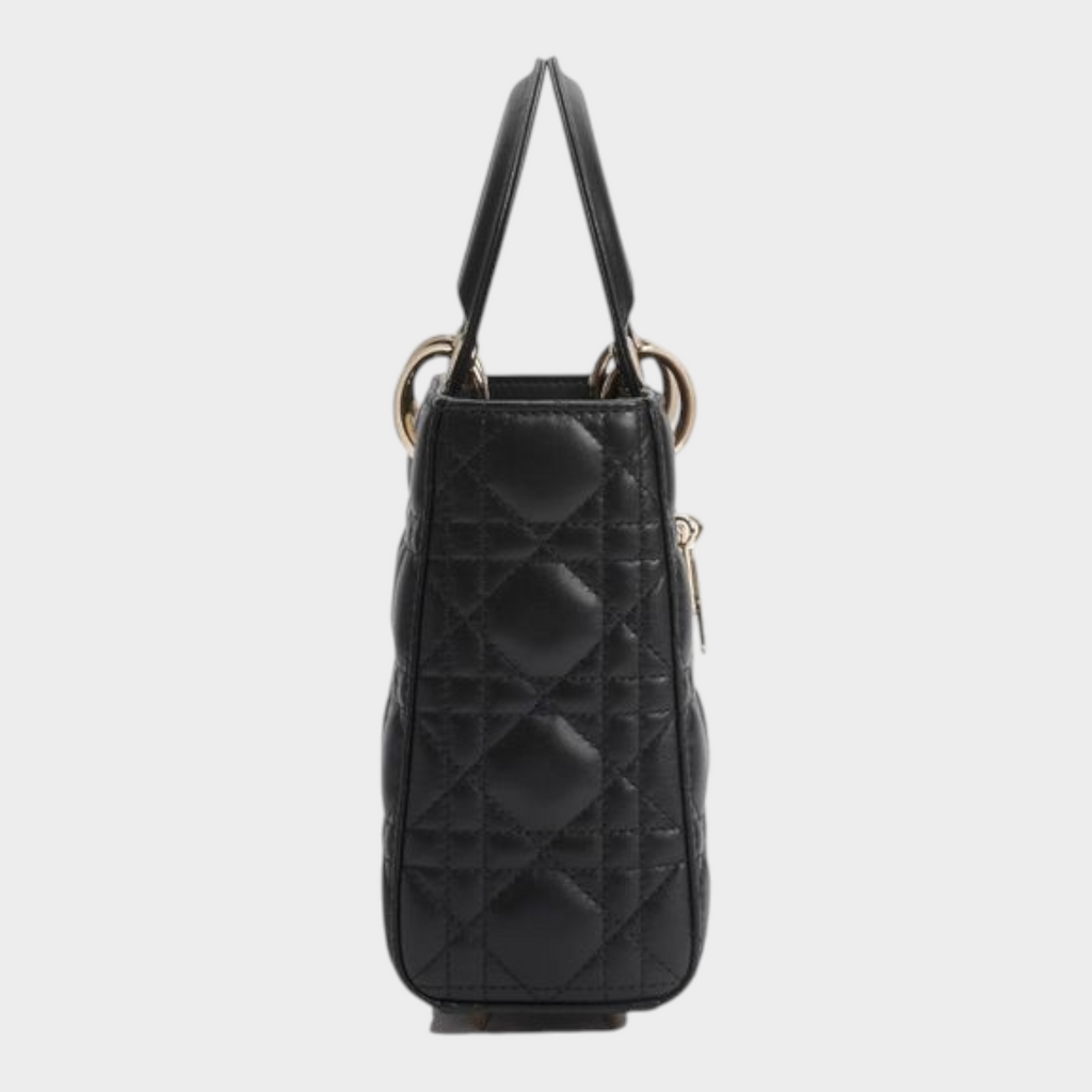 Esmire & Co black quilted lamb leather Dior handbag with pale gold hardware, side view showing top handles.