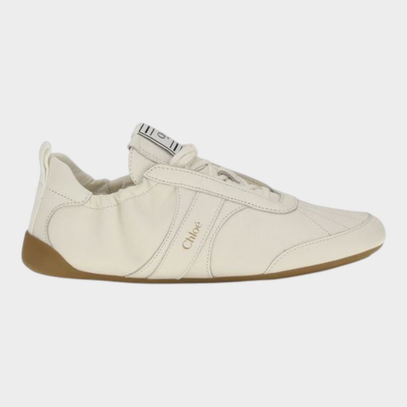 Esmire & Co Chloé beige fabric athletic sneakers with a round toe, lace-up fastening, and flexible rubber sole.