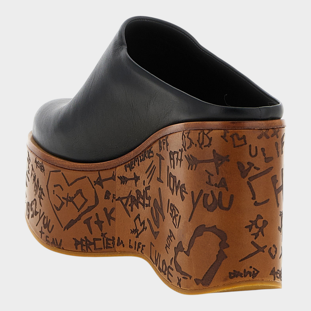 Esmire & Co Chloé black calfskin leather wedge sabot with a sculptural wood-effect heel featuring graffiti engravings.