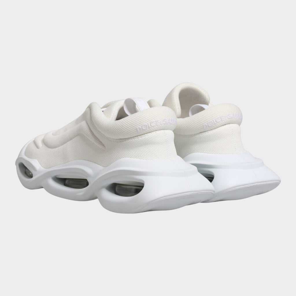 Esmire & Co Dolce & Gabbana white slip-on low top sneakers with a unique wave-inspired rubber sole and logo detail.