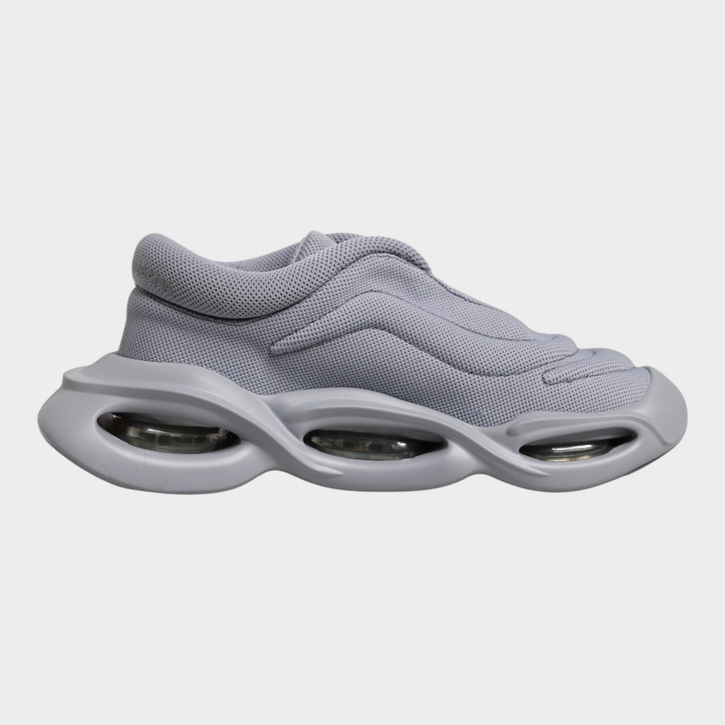Esmire & Co grey slip-on sneakers with a wave-inspired design, textured polyester upper, and chunky rubber sole.