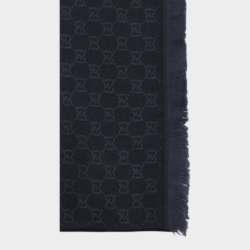 Esmire & Co black wool Gucci scarf featuring an all-over GG embroidered pattern and elegant frayed edges.
