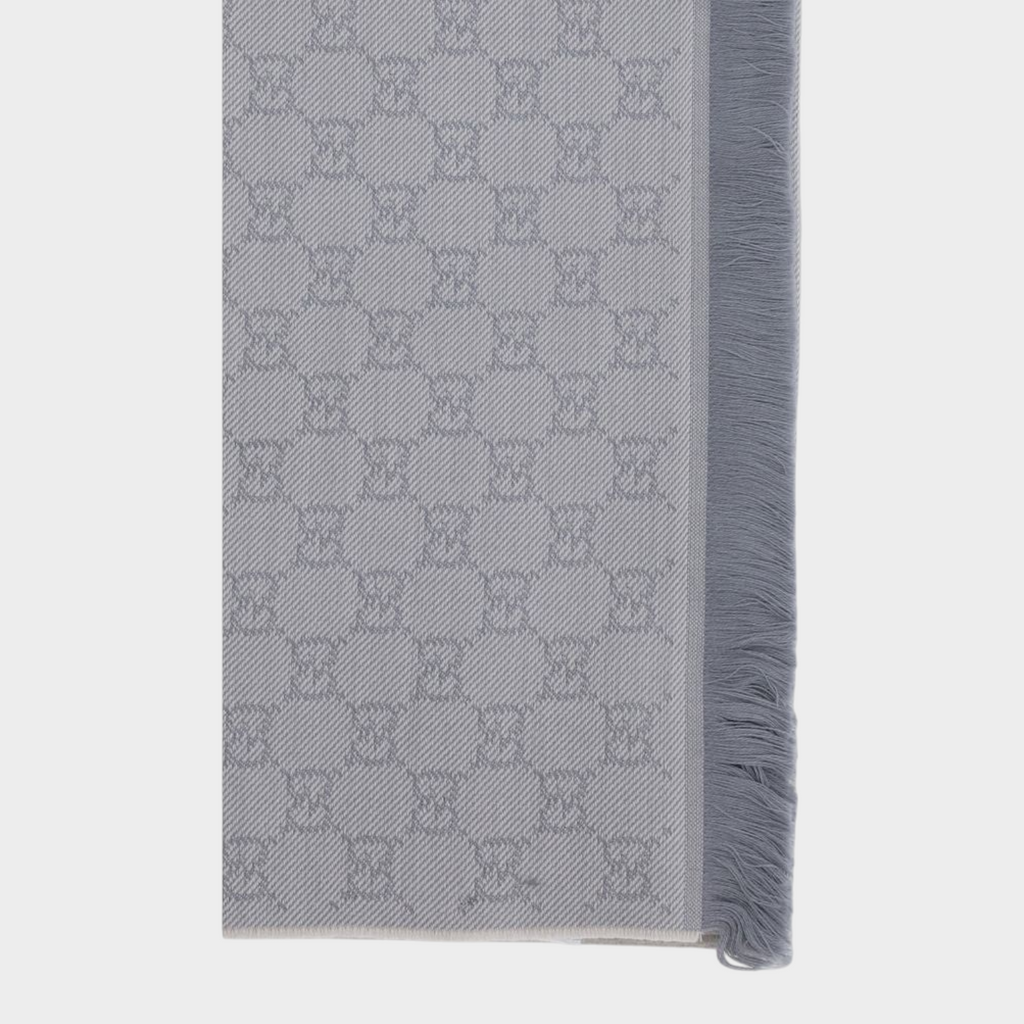 Esmire & Co gray wool Gucci scarf featuring an all-over GG logo embroidery and elegant frayed edge detailing.