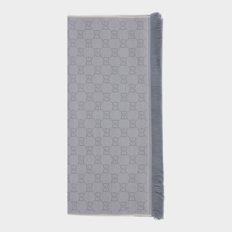 Esmire & Co gray wool Gucci scarf featuring an all-over GG logo embroidery and elegant frayed edge detailing.