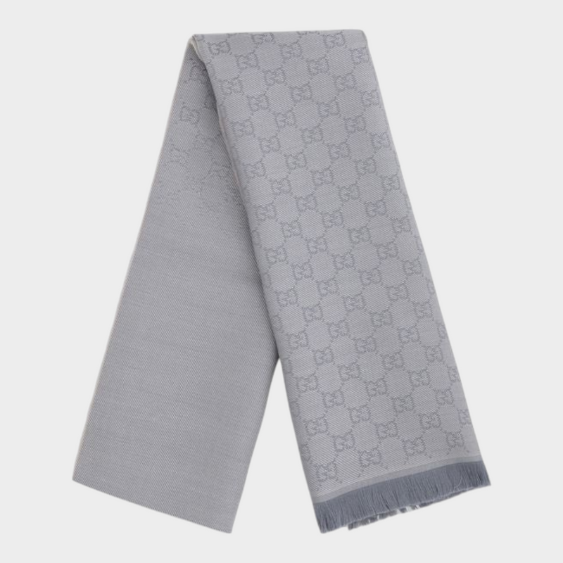 Esmire & Co gray wool Gucci scarf featuring an all-over GG logo embroidery and elegant frayed ends.