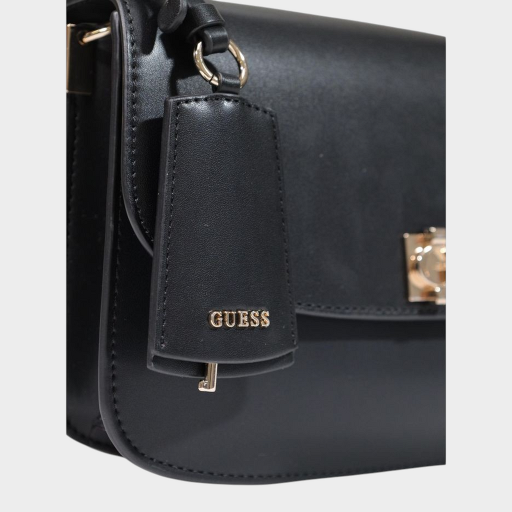 Esmire & Co Guess black polyurethane handbag featuring a gold logo clasp and branded hanging tag detail