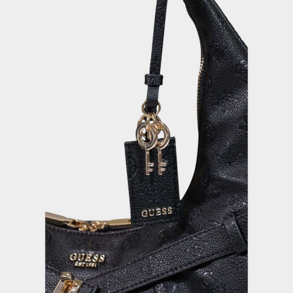 Esmire & Co black Guess Jodi tote bag featuring embossed logo pattern, gold-tone key charms, and metallic hardware.