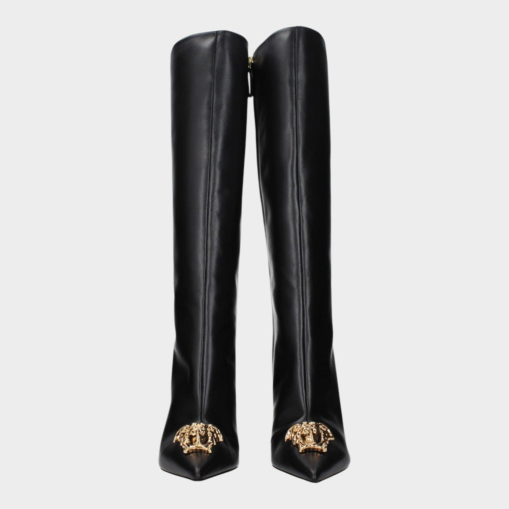 Esmire & Co black leather high heel boots by Versace featuring a gold Medusa front detail and pointed toe design.