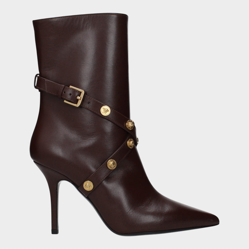 Esmire & Co Versace chocolate brown leather ankle boots with pointed toe, gold Medusa studs, and high stiletto heel.