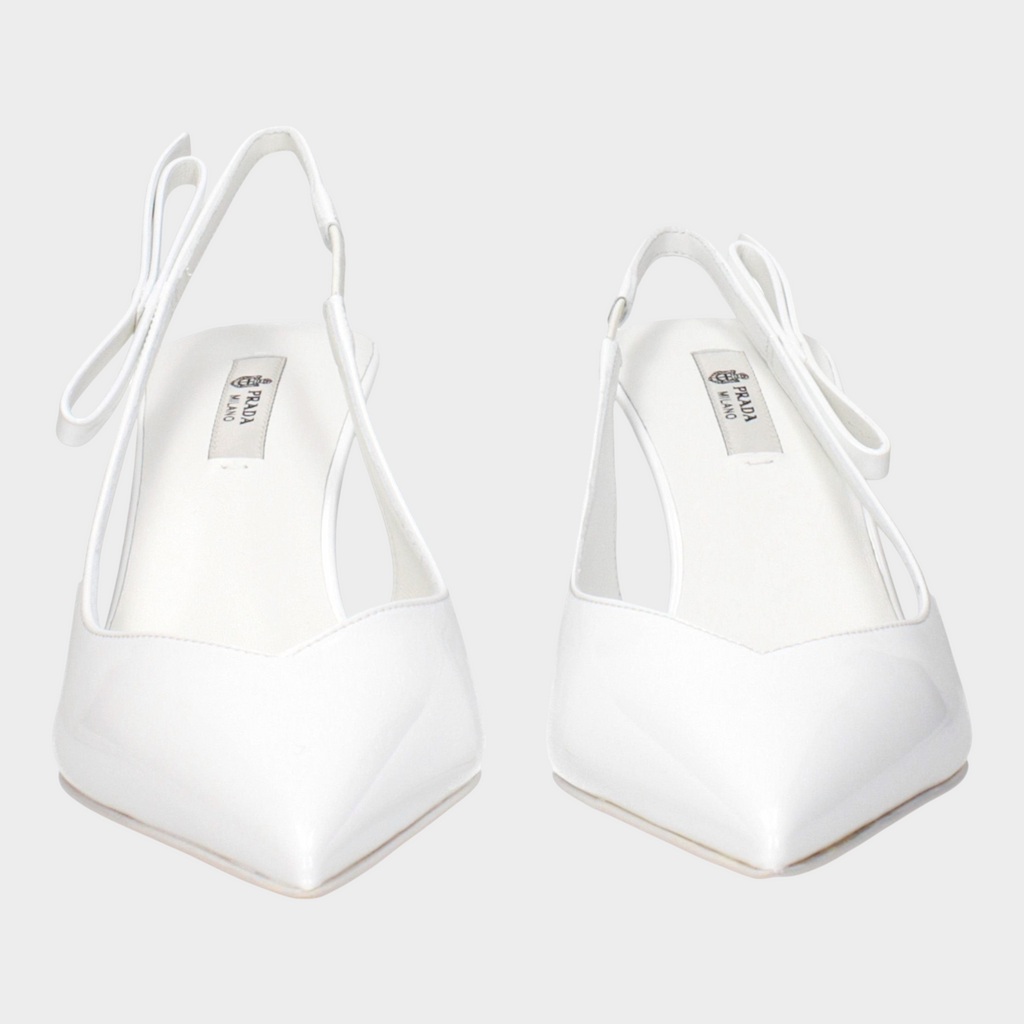 Esmire & Co white patent leather Prada slingback pumps with a pointed toe and bow detail